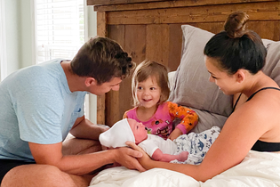 family in bed after home birth